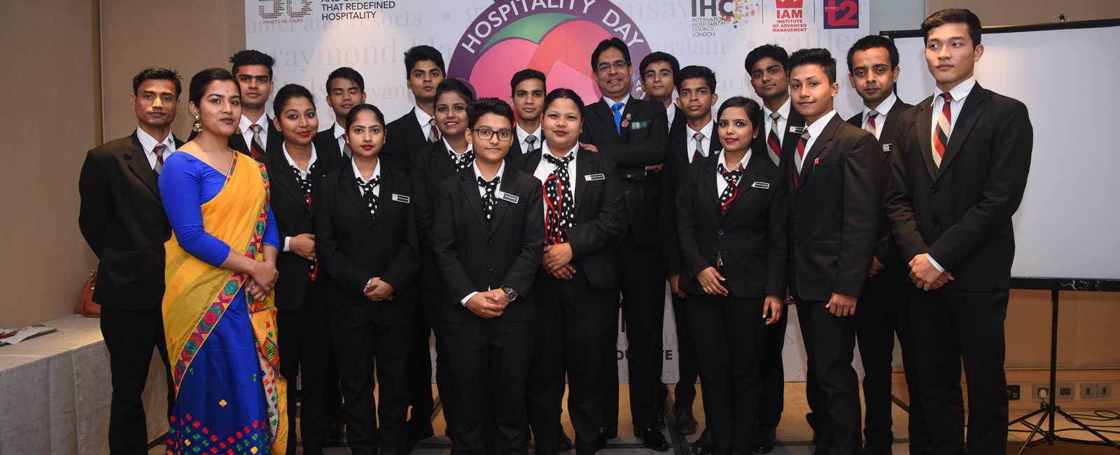 Students and faculty at IAM celebrating Hospitality Day, representing the best hotel management institute in formal attire.